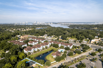 An aerial view of magnolia village with a lake and a city in the background